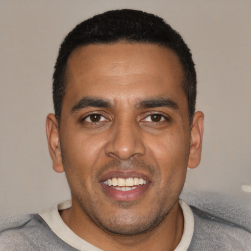 Joyful black young-adult male with short  black hair and brown eyes