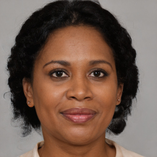 Joyful black adult female with medium  brown hair and brown eyes