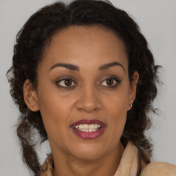 Joyful black adult female with medium  brown hair and brown eyes