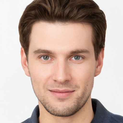 Joyful white young-adult male with short  brown hair and grey eyes