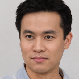 Joyful asian young-adult male with short  brown hair and brown eyes