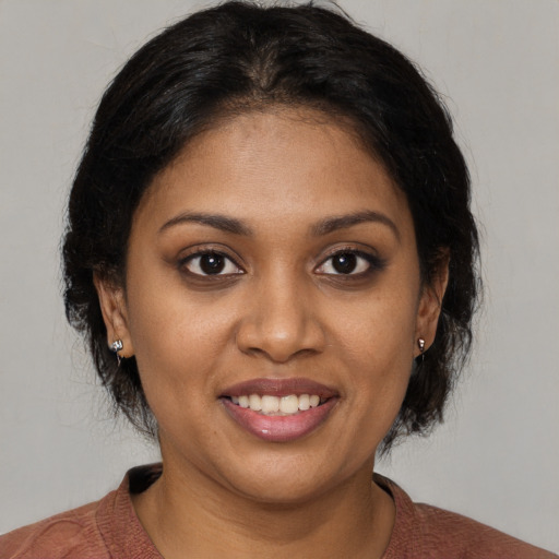 Joyful black young-adult female with medium  brown hair and brown eyes