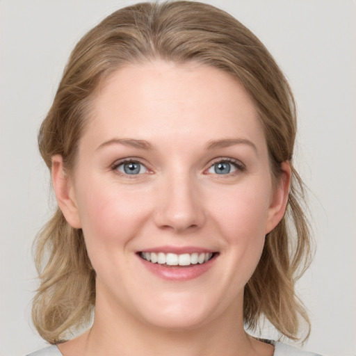 Joyful white young-adult female with medium  brown hair and blue eyes