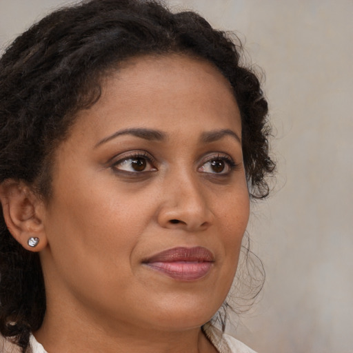 Joyful black young-adult female with long  brown hair and brown eyes