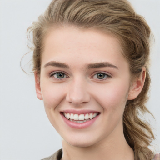 Joyful white young-adult female with long  brown hair and blue eyes