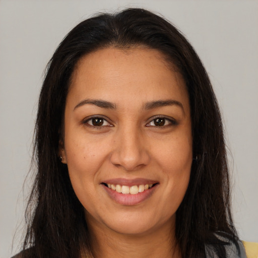 Joyful latino young-adult female with long  brown hair and brown eyes