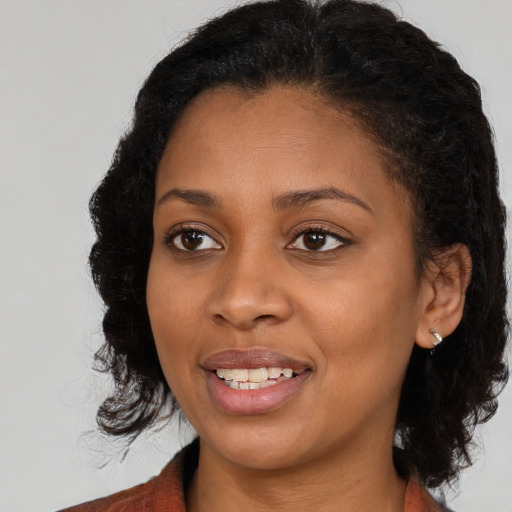 Joyful black young-adult female with medium  brown hair and brown eyes