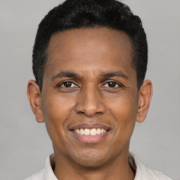 Joyful black young-adult male with short  black hair and brown eyes