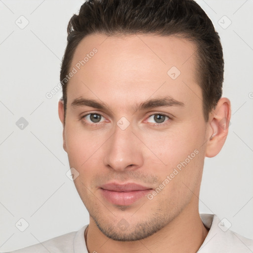 Joyful white young-adult male with short  brown hair and brown eyes