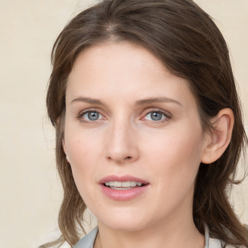 Joyful white young-adult female with medium  brown hair and grey eyes