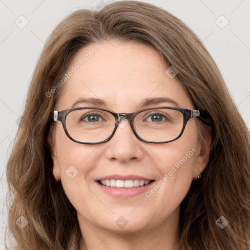 Joyful white adult female with long  brown hair and blue eyes