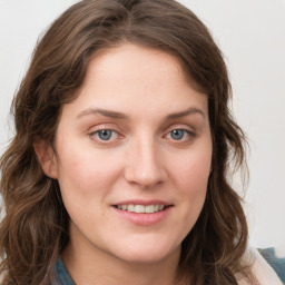 Joyful white young-adult female with long  brown hair and blue eyes