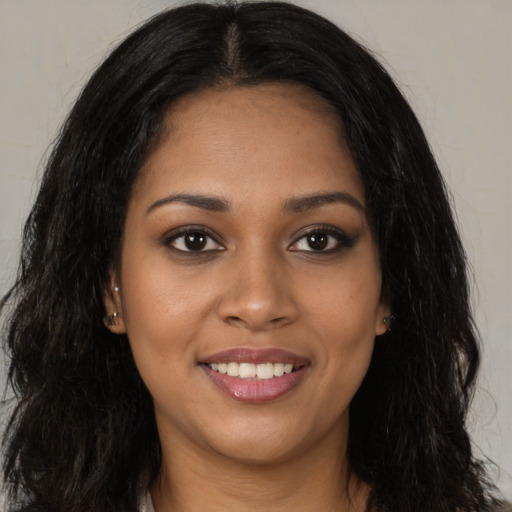 Joyful black young-adult female with long  brown hair and brown eyes