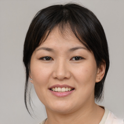 Joyful asian young-adult female with medium  brown hair and brown eyes