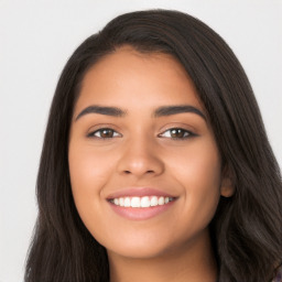 Joyful latino young-adult female with long  brown hair and brown eyes