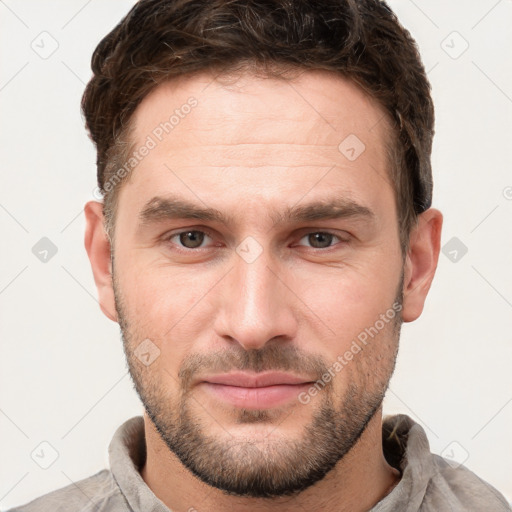 Joyful white young-adult male with short  brown hair and grey eyes