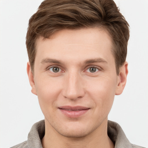 Joyful white young-adult male with short  brown hair and grey eyes