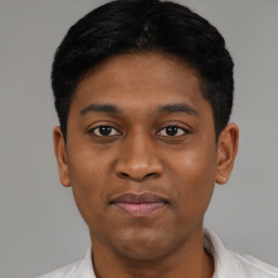 Joyful black young-adult male with short  black hair and brown eyes