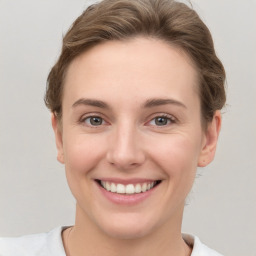 Joyful white young-adult female with short  brown hair and grey eyes