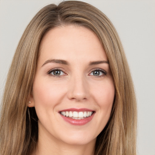 Joyful white young-adult female with long  brown hair and brown eyes