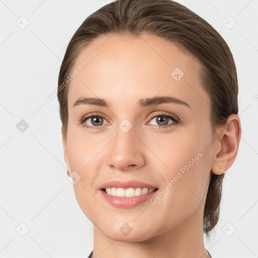 Joyful white young-adult female with medium  brown hair and grey eyes