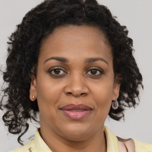 Joyful black adult female with long  brown hair and brown eyes