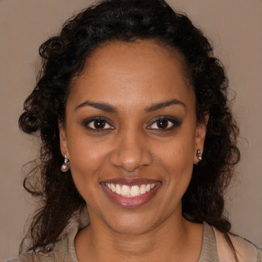 Joyful black young-adult female with long  brown hair and brown eyes