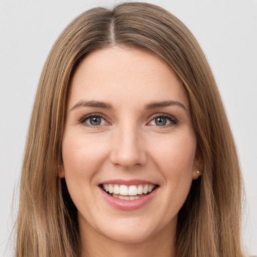 Joyful white young-adult female with long  brown hair and green eyes