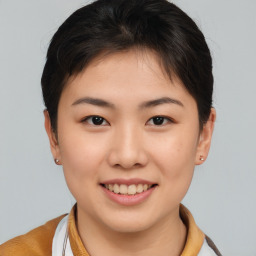 Joyful asian young-adult female with short  brown hair and brown eyes