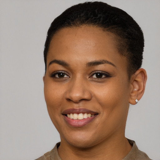 Joyful black young-adult female with short  black hair and brown eyes