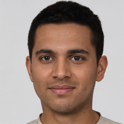 Joyful latino young-adult male with short  brown hair and brown eyes