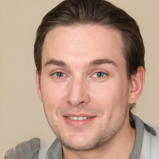 Joyful white young-adult male with short  brown hair and grey eyes