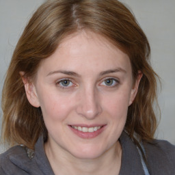 Joyful white young-adult female with medium  brown hair and blue eyes