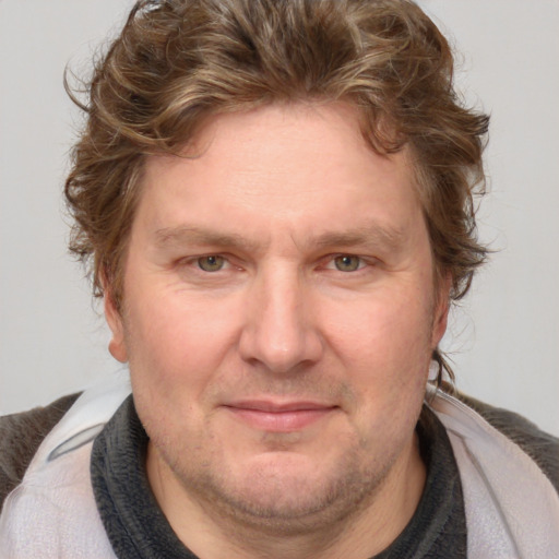 Joyful white adult male with medium  brown hair and blue eyes