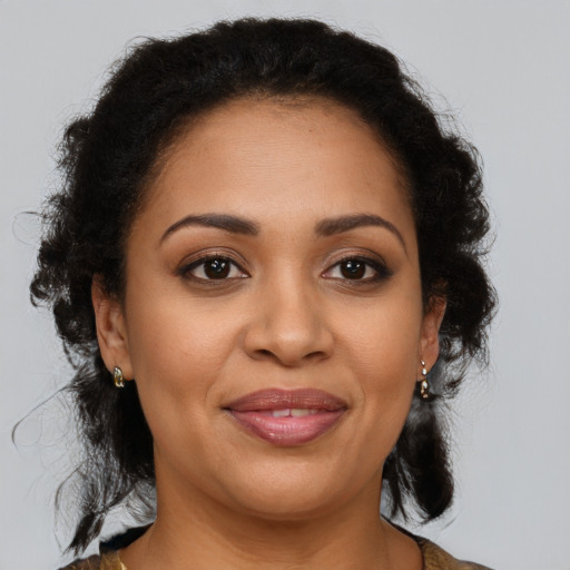 Joyful latino adult female with medium  brown hair and brown eyes