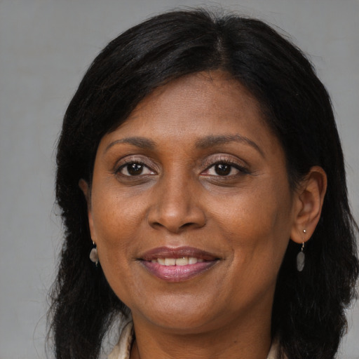 Joyful black adult female with long  brown hair and brown eyes