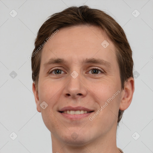 Joyful white young-adult male with short  brown hair and grey eyes