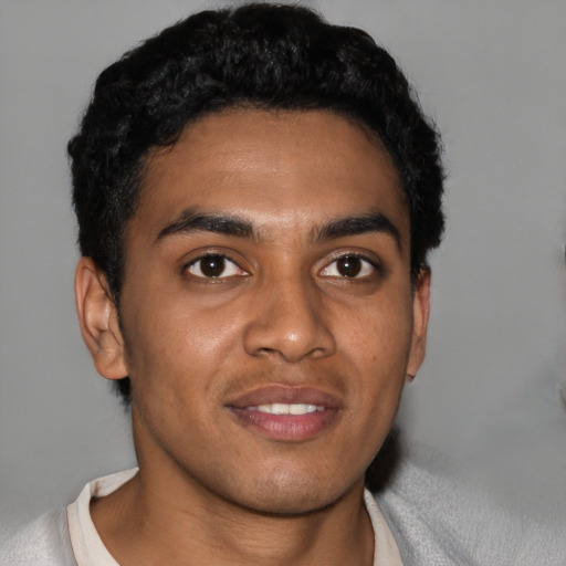 Joyful black young-adult male with short  black hair and brown eyes