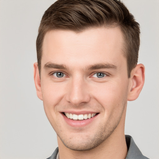 Joyful white young-adult male with short  brown hair and grey eyes