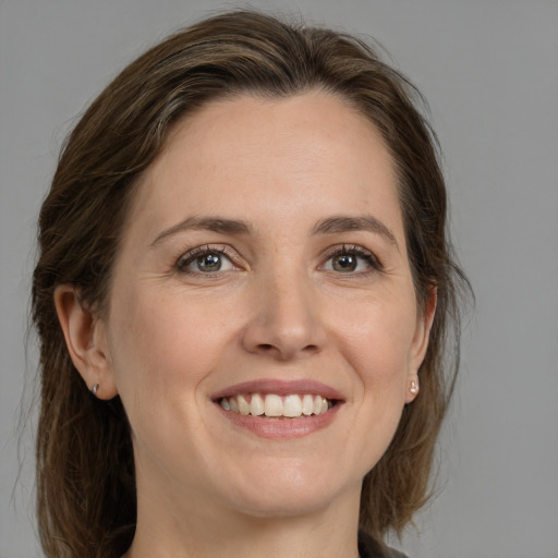 Joyful white adult female with medium  brown hair and grey eyes