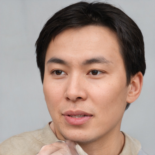 Joyful asian young-adult male with short  brown hair and brown eyes