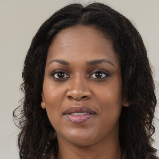 Joyful black young-adult female with long  brown hair and brown eyes