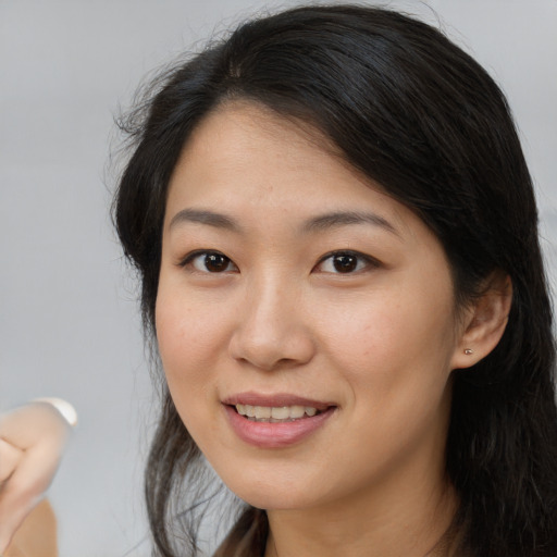 Joyful latino young-adult female with medium  brown hair and brown eyes