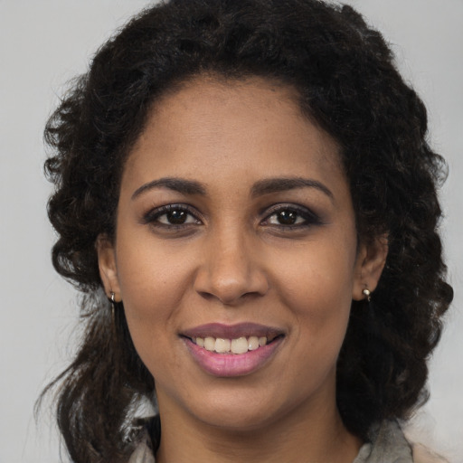 Joyful black young-adult female with long  brown hair and brown eyes