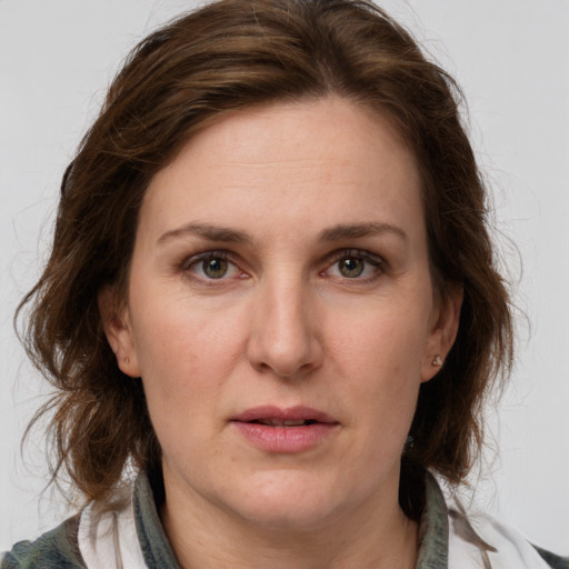 Joyful white adult female with medium  brown hair and green eyes