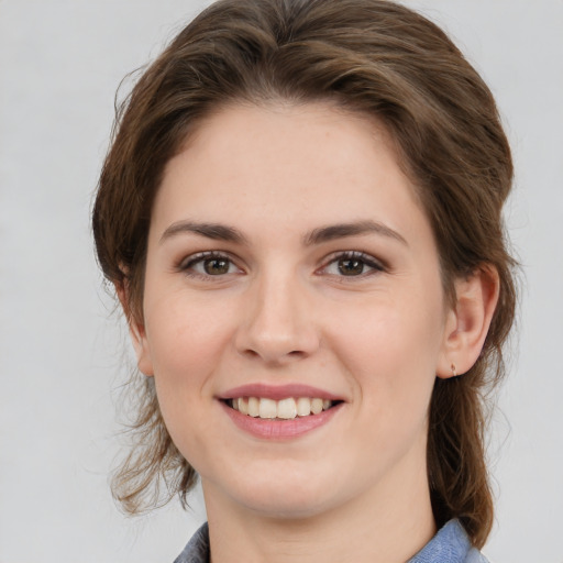 Joyful white young-adult female with medium  brown hair and grey eyes