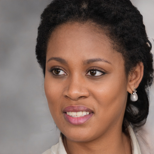 Joyful black young-adult female with long  brown hair and brown eyes