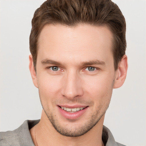 Joyful white young-adult male with short  brown hair and grey eyes