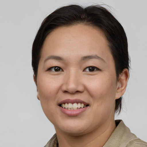 Joyful asian adult female with short  brown hair and brown eyes