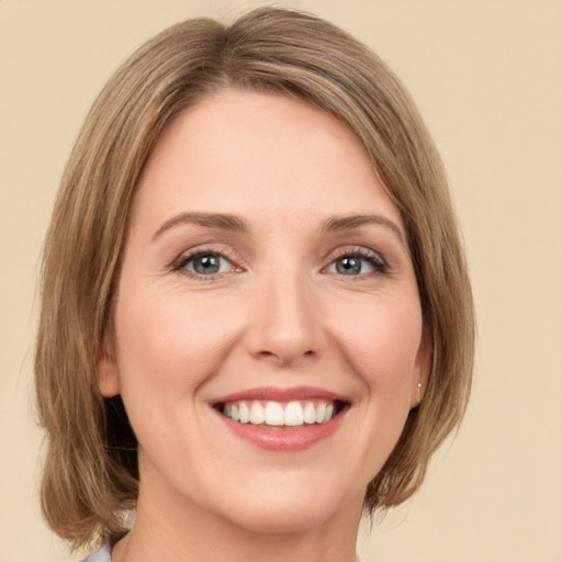 Joyful white young-adult female with medium  brown hair and green eyes